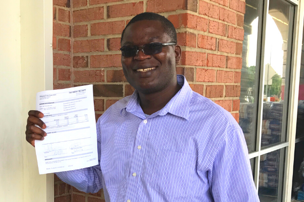 man holding up loan closing document smiling